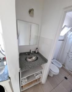 Un baño con lavabo, inodoro y espejo. en Departamento centro ciudad, en Mendoza