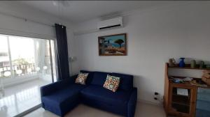 ein blaues Sofa im Wohnzimmer mit Fenster in der Unterkunft Tenerife Golf Park Apartment in San Miguel de Abona