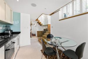 a kitchen with a glass table and some chairs at LONDON ONE BED ANNEX in London