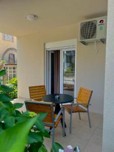 a patio with a table and chairs and a window at Apartmani Bekonja in Tivat