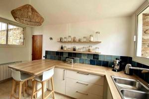 een keuken met een houten tafel en een wastafel bij Eole, villa d'architecte, vue mer, piscine in Bormes-les-Mimosas
