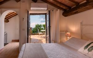 1 dormitorio con 1 cama y puerta abierta en Castel Brunello, en Montalcino