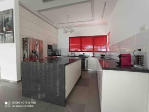 a large kitchen with red cabinets and a black counter top at Villa SUN in Ashkelon