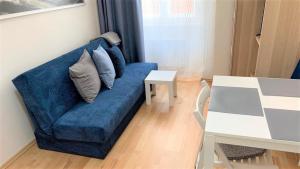 a living room with a blue couch and a table at Side Street Apartments in Prague