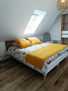 a bedroom with a bed with yellow pillows on it at la bouée rose in Sangatte