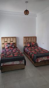 duas camas sentadas uma ao lado da outra num quarto em Résidence Miftah Sahil Anza em Agadir