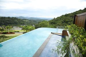uma piscina com montanhas ao fundo em Resort Ecoar em Gaspar