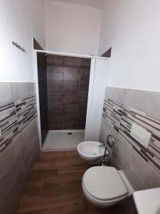 Vista mare rooms في Gasponi: حمام مع مرحاضين ودش
