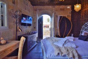 a bedroom with a bed and a desk and a tv at Chapel 5 Boutique Suites B&B in Naxxar