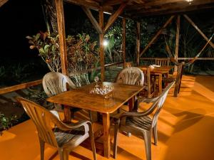 un tavolo e sedie in legno su un patio di Mompiche Island Hostel a Mompiche