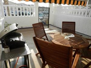 a patio with a wooden table and chairs at Casa Tarca Gran Alacant in Alicante
