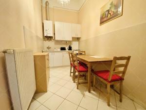 a kitchen with a table and chairs and a counter at Garibaldi Apartman in Budapest