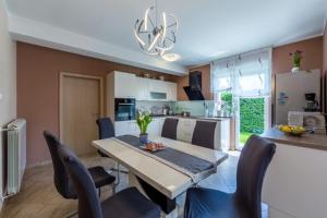 een eetkamer en keuken met een tafel en stoelen bij KARLO in Čavle