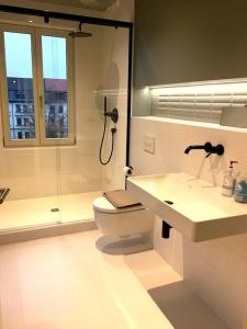 La salle de bains est pourvue de toilettes, d'un lavabo et d'une douche. dans l'établissement Lax und Sülze, à Leipzig