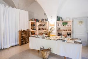 a room with a table with books on it at Ostello dei Giardini di Pomona in Cisternino +35 photos