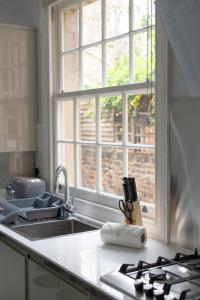 a kitchen counter with a sink and a window at Charming Character House London in London