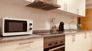 une cuisine avec un four micro-ondes sur un comptoir dans l'établissement LA BALLENERA, à Cangas