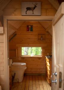 a bathroom with a toilet in a log cabin at Troll House Eco-Cottage, Nuuksio for Nature lovers, Petfriendly in Espoo