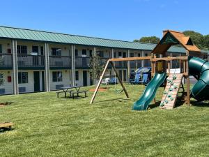 een speeltuin met een glijbaan in een tuin bij Sunbird Cape Cod Resort in West Yarmouth