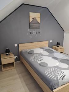 1 dormitorio con 1 cama y una señal de sueño en la pared en Gîte Avec Spa et Sauna Privatifs, en Poullaouen