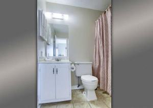 a bathroom with a white toilet and a sink at Gulf Shores Plantation Condos in Gulf Shores