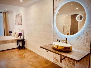 a bathroom with a sink and a mirror at La Vie - Apartmány in Telč