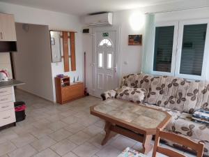 ein Wohnzimmer mit einer Couch und einem Couchtisch in der Unterkunft Apartman Tamara in Sumartin