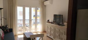 uma sala de estar com uma televisão de ecrã plano numa cómoda em Edf. Albaida I, 5º H em Nerja