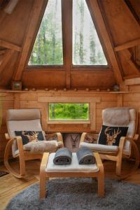 a room with two chairs and a table in a cabin at Troll House Eco-Cottage, Nuuksio for Nature lovers, Petfriendly in Espoo
