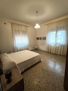 um quarto com uma cama grande e 2 janelas em Appartamento luminoso in zona centrale em Montesilvano