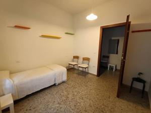 1 dormitorio con cama, sillas y puerta en Appartamento luminoso in zona centrale, en Montesilvano