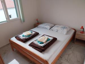 ein Schlafzimmer mit einem Bett mit Handtüchern darauf in der Unterkunft Apartman Tamara in Sumartin
