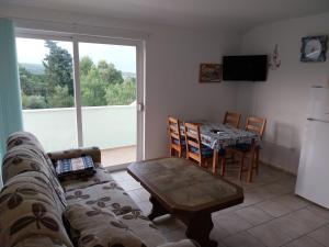 ein Wohnzimmer mit einer Couch und einem Tisch in der Unterkunft Apartman Tamara in Sumartin