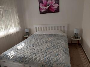 um quarto com uma cama e duas mesas com candeeiros em NEÐO Apartments Brda em Tivat
