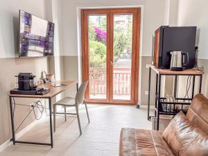 un salon avec un canapé, une table et une télévision dans l'établissement Bleisure Inn, à Cagliari