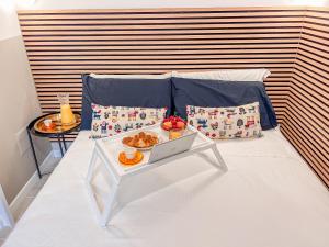 - un lit avec une table et un plateau de nourriture dans l'établissement Bleisure Inn, à Cagliari