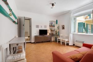 a living room with a couch and a tv at Oceane Paradise- Charlot in Levanto