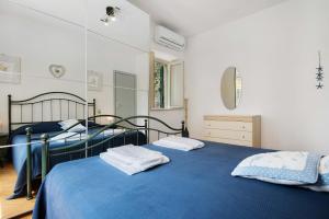 a bedroom with two beds with blue sheets and a mirror at Oceane Paradise- Charlot in Levanto
