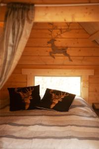 a bed in a log cabin with a window at Troll House Eco-Cottage, Nuuksio for Nature lovers, Petfriendly in Espoo