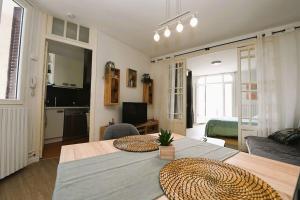 uma sala de estar com uma mesa e uma sala de estar em Appartement 2 à 4 pers cosy à proximité du centre em Bagnères-de-Bigorre