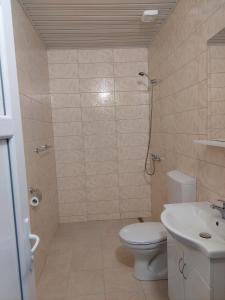 uma casa de banho com um WC, um chuveiro e um lavatório. em NEÐO Apartments Brda em Tivat