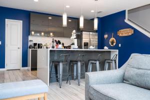 a kitchen with blue walls and a bar with stools at Enchanting Four Bedrooms Townhouse at Le Reve Resort (211021) in Kissimmee