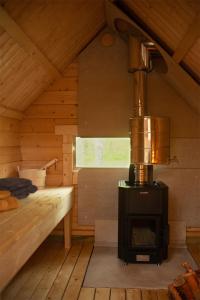 um quarto com um fogão numa cabina de madeira em Troll House Eco-Cottage, Nuuksio for Nature lovers, Petfriendly em Espoo