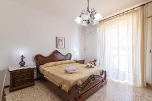 a bedroom with a large bed and a chandelier at Angolo di cielo in Castellammare del Golfo
