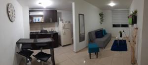 a kitchen and living room with a table and a couch at Apartamentos con Piscina cerca a Parque del Cafe in Montenegro