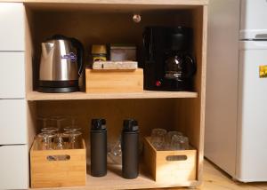 a cupboard with a coffee maker and glasses in it at Troll House Eco-Cottage, Nuuksio for Nature lovers, Petfriendly in Espoo