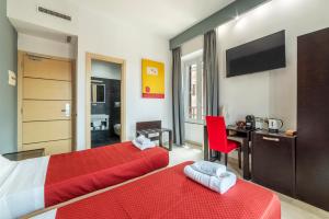 a bedroom with two beds and a desk and a television at S.Marco Guesthouse in Rome
