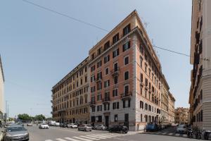 a large brick building on a city street with cars at S.Marco Guesthouse in Rome
