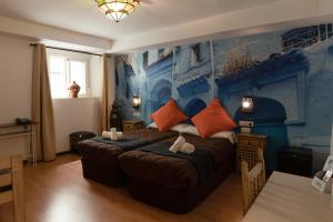 Hotel Alquimia Cadiz في كاديز: غرفة نوم بسرير كبير بجدار ازرق