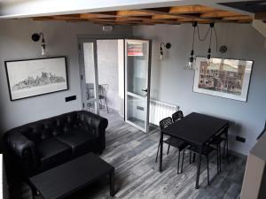a living room with a black couch and a table at La Casa de Anne Marie in Villarejo del Valle